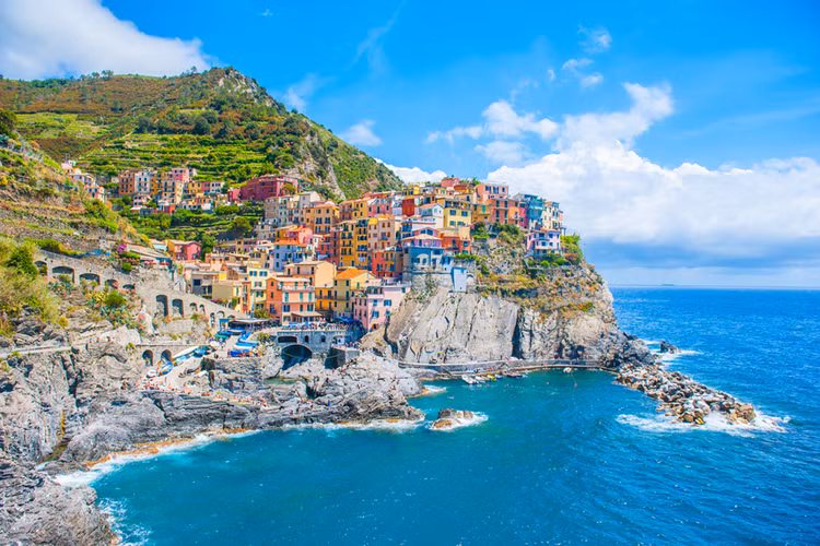 Ngôi làng Cinque Terre nằm dọc bờ biển Niviera của Ý. Những ngôi nhà ở đây được xây trên các vách đá, tạo nên những khối màu sặc sỡ mà lại hài hòa với màu nước biển xanh thẳm. Nét kiến trúc độc đáo của Cinque Terre còn được thể hiện qua hình ảnh các ngôi nhà được nối với nhau bằng những bậc thang nhỏ dẫn xuống biển.