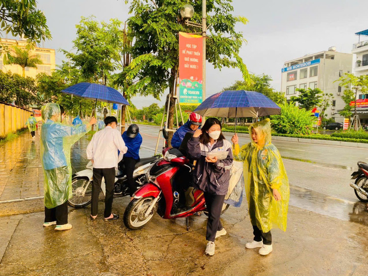 Không quản ngại mưa gió, những màu &quot;áo xanh&quot; hăng say, miệt mài che ô cho thí sinh vào phòng thi.
