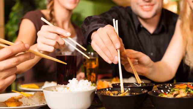 Gắp thức ăn cho nhau. Ảnh minh họa