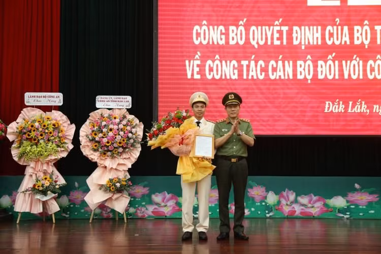 Thượng tướng Lương Tam Quang, Thứ trưởng Bộ Công an trao Quyết định và tặng hoa chúc mừng Thượng tá Trần Quang Hiếu. Ảnh: T.D.