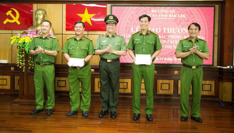 Thiếu tướng Lê Vinh Quy - giám đốc Công an tỉnh Đắk Lắk (giữa) trao thưởng đột xuất cho Công an thị xã Buôn Hồ và Phòng CSHS Công an tỉnh.