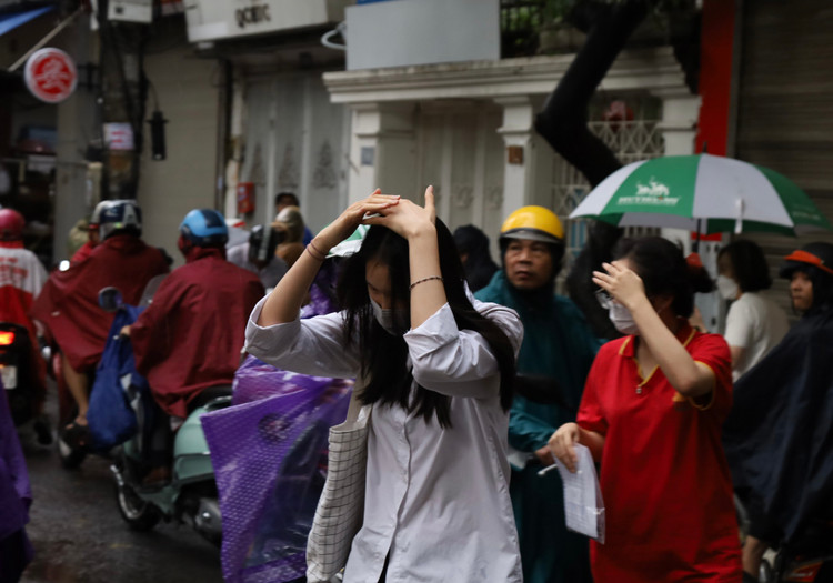 Sáng nay, các thí sinh vội vã vào phòng thi dưới cơn mưa lớn.