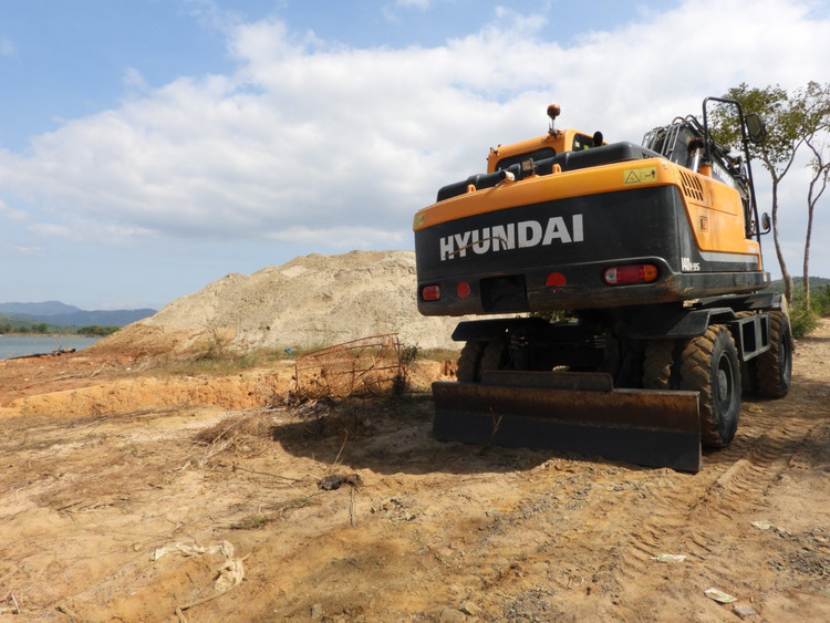 Chiếc máy xúc hiệu Hyundai cỡ lớn tại bãi tập kết cát.