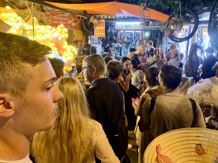 Đông đảo du khách nước ngoài kiên nhẫn xếp hàng đợi đến lượt trong ngõ nhỏ cạnh đường tàu trên phố Trần Phú tối ngày 21/8.