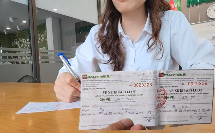 Nhân viên Mai Linh WILLER viết và đưa vé xe cho hành khách tại văn phòng Thanh Hóa.