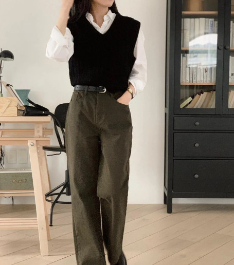 Sơ mi trắng + áo len gile và quần màu rêu ghi điểm ở nét trẻ trung, tinh tế. Nếu sơ vin và tô điểm một chiếc thắt lưng dáng mảnh, phong cách càng được nâng tầm.