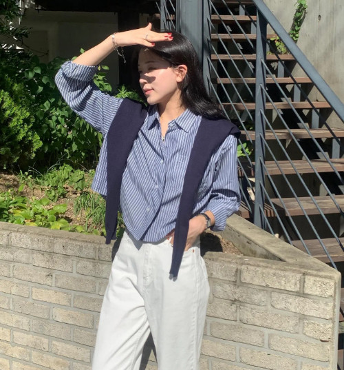 Tới tận mùa thu năm nay, công thức áo sơ mi kết hợp với áo len quàng vai vẫn thịnh hành. Mẫu áo sơ mi kẻ sọc màu xanh biển đảm bảo vẻ hài hòa.