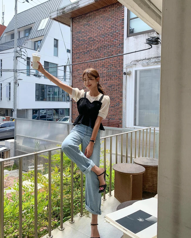 Phái đẹp hãy thử kết hợp áo gilet với một chiếc áo blouse tay bồng. Combo này khá lý tưởng để mix cùng quần jeans xanh, tạo nên outfit vừa trẻ trung, vừa yêu kiều, sang chảnh. Đôi sandal quai ngang &quot;ăn nhập&quot; hoàn hảo với vẻ nữ tính của outfit. Kiểu giày này còn là &quot;bảo bối&quot; hack dáng mà chị em nào cũng nên có.