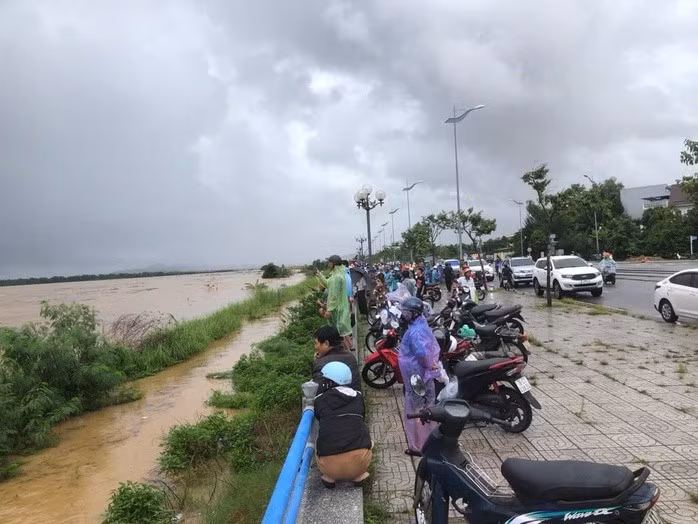 Nhiều người dân đang xem lực lượng chức năng giải cứu 8 người dân đang mắc kẹt giữa dòng nước lũ sông Trà Khúc.