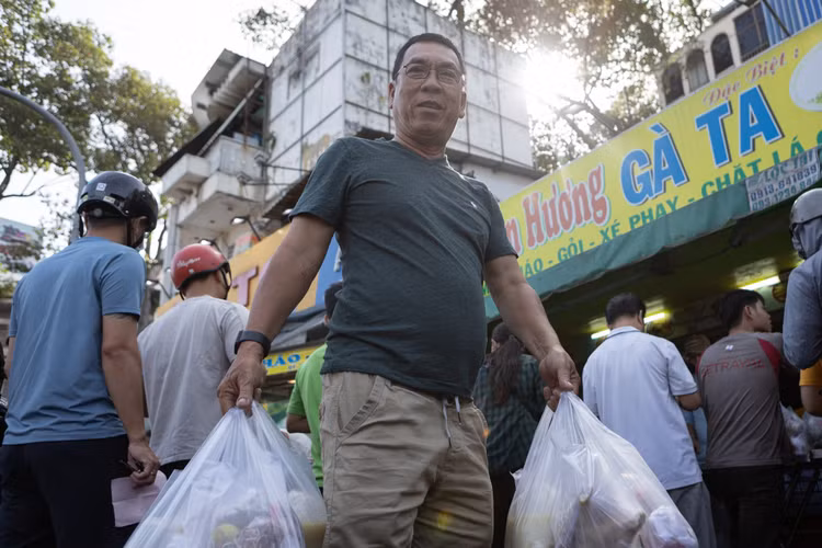 Ông Lý Chí Hùng (phường Nhiêu Lộc) di chuyển hơn 15 phút để đến nơi bán gà. "Đây là quán gà luộc có tiếng, thịt chắc, da giòn sần sật nên gia đình tôi thường xuyên mua", ông nói. Ông Hùng cho biết đại diện 4 gia đình họ hàng để mua 4 con gà trống luộc.