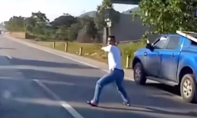 Người đàn ông cầm gậy golf lao ra giữa đường dọa vụt vào chiếc ôtô con đang đi đến.