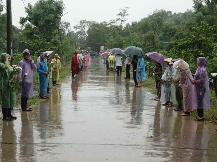 Hàng trăm người dân &quot;đội mưa&quot; chờ đón Liệt sĩ Lê Ánh Sáng về với đất mẹ.