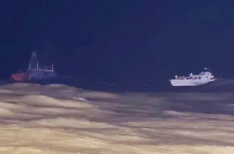 Lực lượng chức năng tiếp cận tàu cá gặp nạn để cứu hộ các thuyền viên.