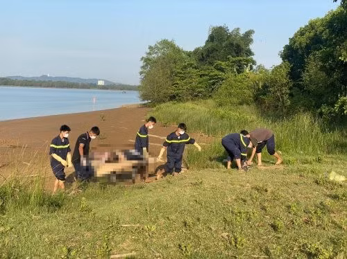 Lực lượng chức năng đưa thi thể nạn nhân lên bờ.