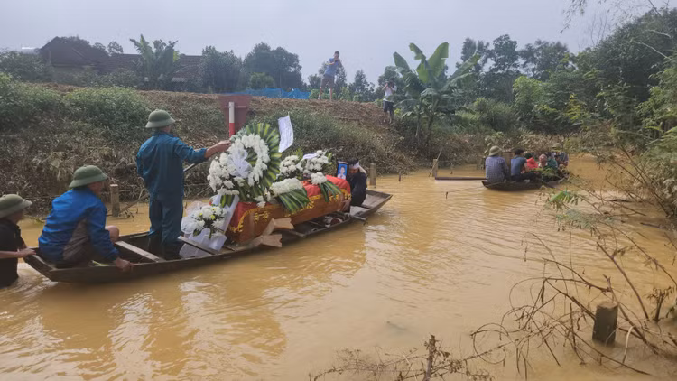 Người thân cùng chính quyền địa phương dùng thuyền để di chuyển quan tài em D. ra nghĩa trang.