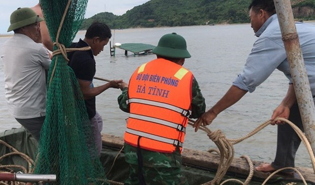 Lực lượng chức năng cùng người dân đang lai dắt phương tiện bị chìm vào cảng cá Cửa Sót.