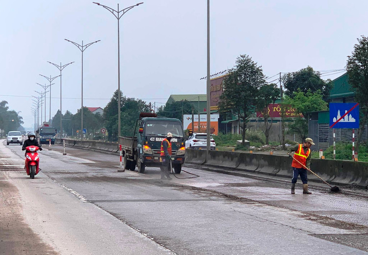 Công nhân làm sạch nền đường trước khi thảm nhựa.