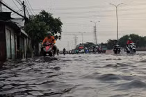 Người dân TP HCM bì bõm trong nước ngập sau mưa trái mùa kéo dài