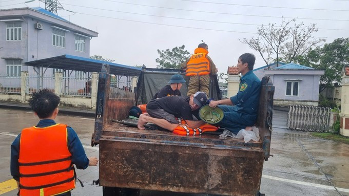 Lực lượng chức năng vận chuyển người bị nạn qua vùng ngập lũ để đi cấp cứu/Ảnh SGGP