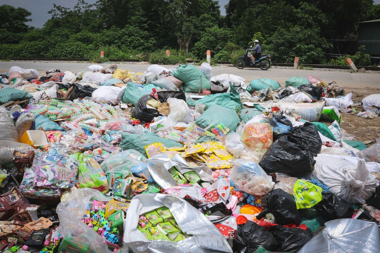 Một bãi rác bánh kẹo và đồ ăn nhanh hết hạn sử dụng bị đổ bỏ tại bãi rác ở KCN La Phù. (Ảnh tienphong.vn)