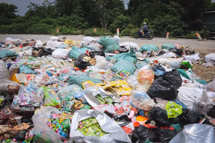 Một bãi rác bánh kẹo và đồ ăn nhanh hết hạn sử dụng bị đổ bỏ tại bãi rác ở KCN La Phù. (Ảnh tienphong.vn)