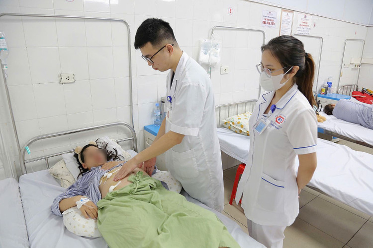 Bác sĩ khoa Ngoại thăm khám, kiểm tra lại vết mổ cho người bệnh. Ảnh BV