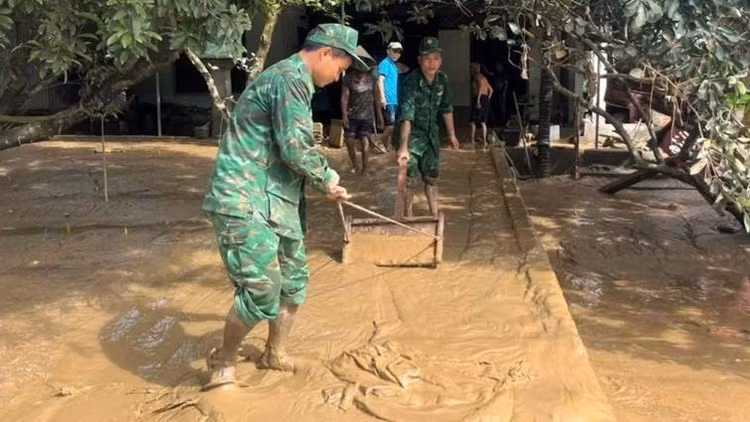 Cán bộ, chiến sĩ Bộ đội Biên phòng tỉnh Nghệ An giúp đỡ nhân dân dọn dẹp bùn đất sau lũ/Ảnh nhandan.vn.
