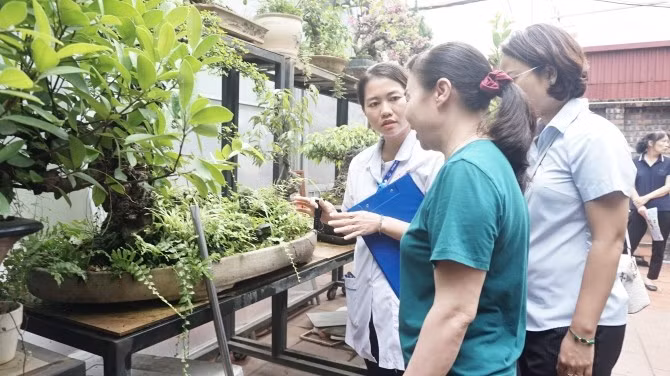 Cán bộ y tế đang tuyên truyền hướng dẫn người dân diệt bọ gậy/loăng quăng ngay để không cho muỗi gây bệnh sốt xuất huyết vào đẻ trứng. Ảnh CAND