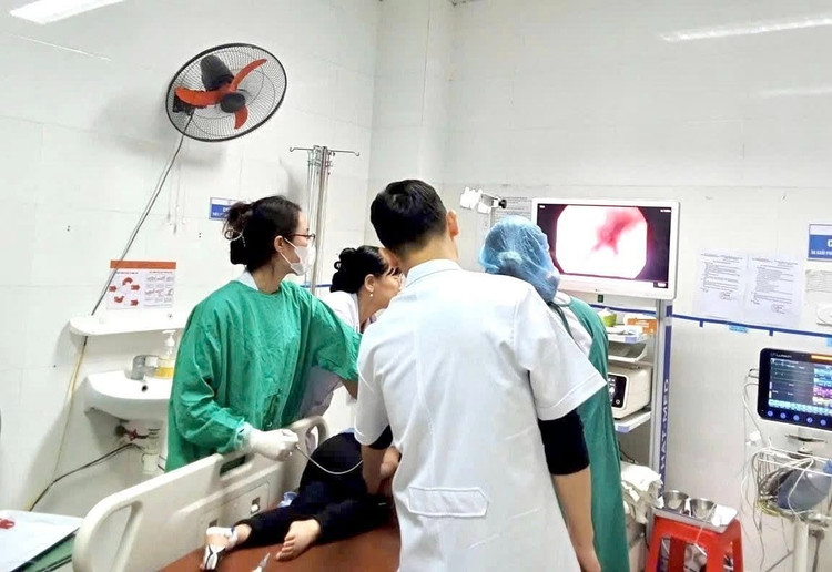 Các bác sĩ thực hiện nội soi gắp dị vật cho bệnh nhân. Ảnh BV
