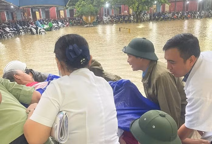 Lực lượng chức năng và nhân viên y tế di dời bệnh nhân tại Bệnh viện Trung ương Huế lên tầng cao để tránh ngập. Ảnh: SKĐS