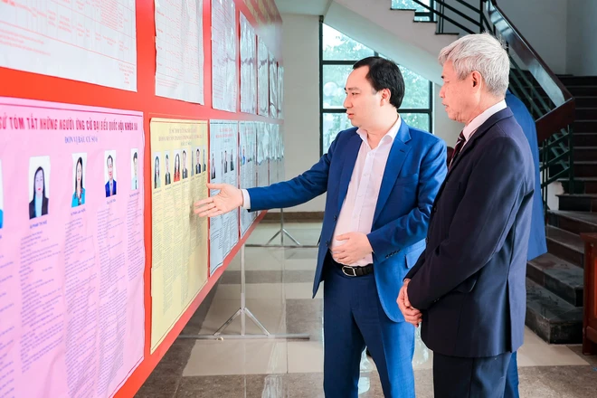 Ông Vũ Văn Tiến, Ủy viên Đoàn Chủ tịch, Trưởng Ban Tuyên giáo Cơ quan Ủy ban Trung ương MTTQ Việt Nam cùng cử tri xem thông tin người ứng cử