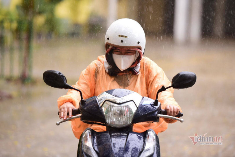 Thí sinh đến trường thi môn Toán trong cơn mưa