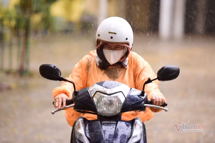 Thí sinh đến trường thi môn Toán trong cơn mưa