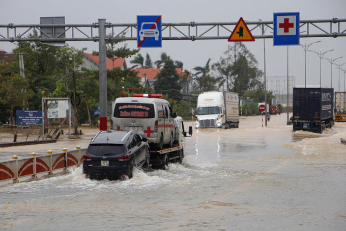 Nhiều xe ôtô con phải nhờ xe cứu hộ mới qua được đoạn đường ngập. Ảnh: Võ Thạnh