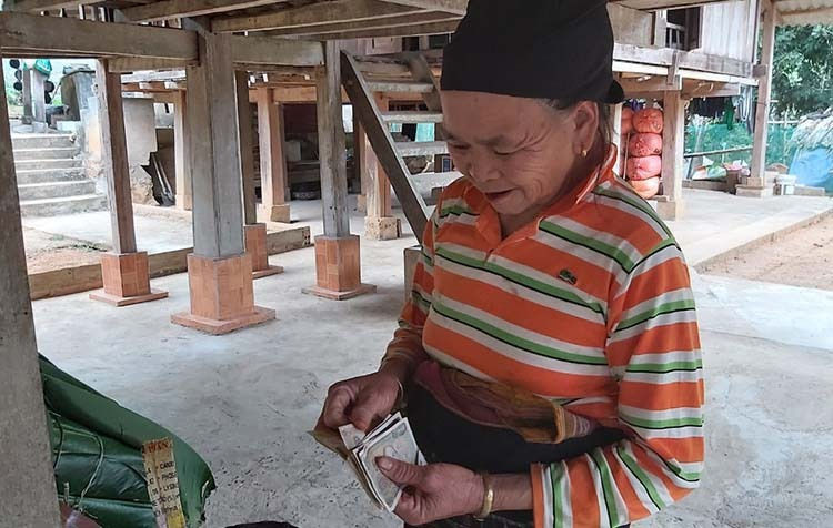 Cụ tương nhẩm tính số tiền thu được sau một ngày vào rừng săn lá dong. Ảnh: Lê Hoàng.