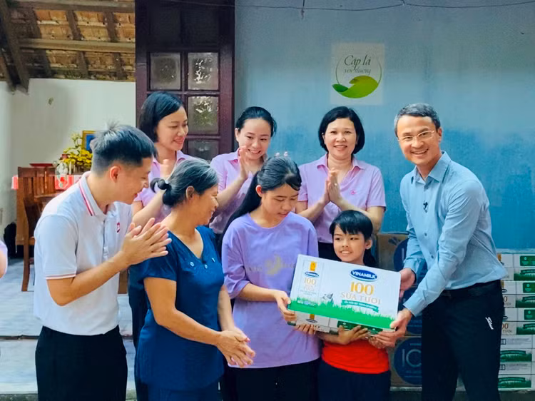 Ông Ngô Công Thắng, Giám đốc Nhà máy sữa Vinamilk Nghệ An đại diện công ty và Quỹ sữa Vươn cao Việt Nam thăm hỏi gia đình và trao tặng học bổng trị giá 50 triệu đồng để hỗ trợ chị em Đạt.