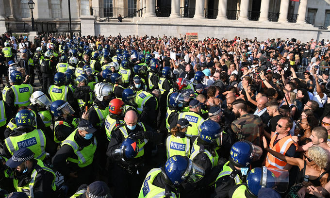 Cảnh sát Anh cố gắng ngăn người biểu tình phản đối vaccine và các biện pháp hạn chế phòng ngừa Covid-19 tại quảng trường Trafalgar ở London tháng trước. Ảnh: AFP.