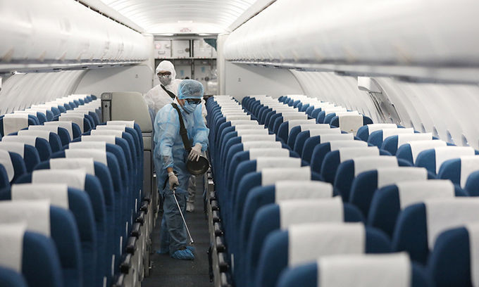 Nhân viên phiun hóa chất tẩy trùng máy bay để ngăn nCoV lây lan, ngày 2/4. Ảnh: Ngọc Thành.