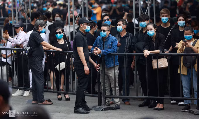 An ninh thắt chặt tại tang lễ. Nhiều khán giả đứng ngoài hàng rào nhà tang lễ để chờ đến giờ viếng cố danh hài. Ảnh: Hữu Khoa.