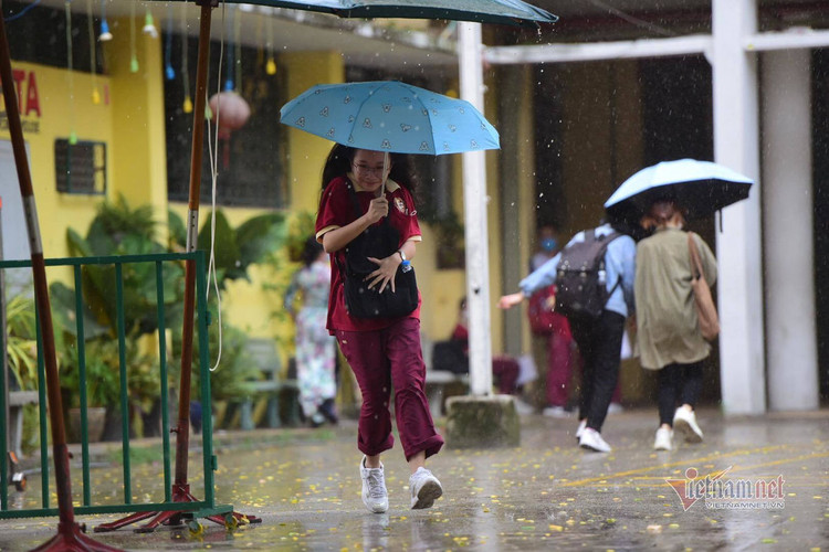 Thí sinh đến trường thi môn Toán trong cơn mưa