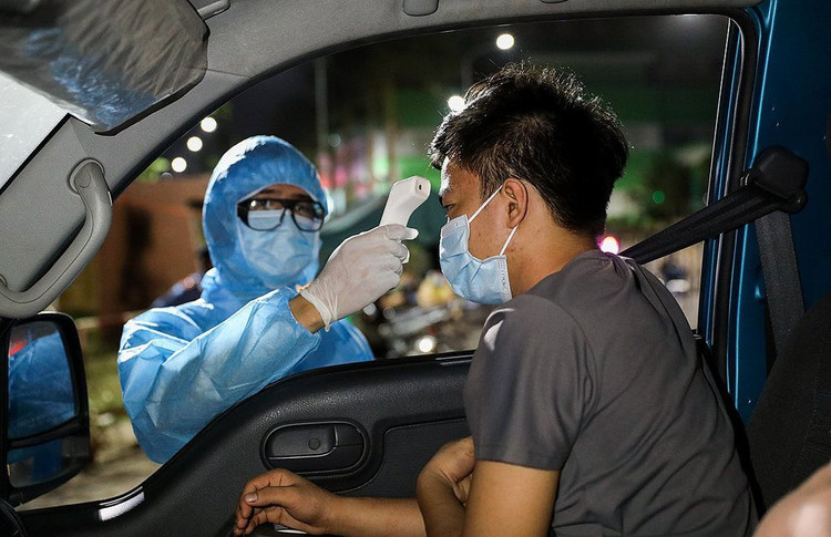 Nhân viên y tế tiến hành đo thân nhiệt, khai báo y tế các xe vào TP HCM. Ảnh: Quỳnh Trần.