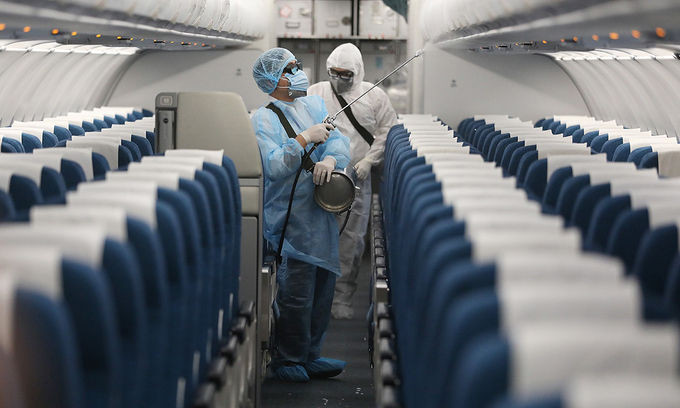 Nhân viên y tế khử trùng bên trong máy bay tại sân bay Nội Bài. Ảnh: Bá Đô