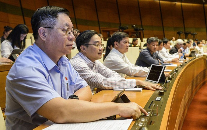 Đại biểu bấm nút thông qua dự án luật, nghị quyết tại kỳ họp thứ 10, Quốc hội khóa 14. Ảnh: Trung tâm báo chí Quốc hội