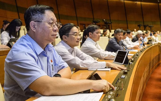 Đại biểu bấm nút thông qua dự án luật, nghị quyết tại kỳ họp thứ 10, Quốc hội khóa 14. Ảnh: Trung tâm báo chí Quốc hội