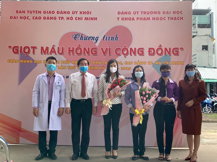Ban Giám hiệu nhà trường gồm PGS.TS.BS Ngô Minh Xuân - Hiệu trưởng (áo sơ mi trắng) và PGS.TS.BS Nguyễn Thanh Hiệp - Hiệu phó (áo blouse trắng) đã tặng hoa cảm ơn BS Nguyễn Phương Liê - Phó Giám đốc Bệnh viện Truyền máu - Huyết học (đứng thứ tư từ trái qua).