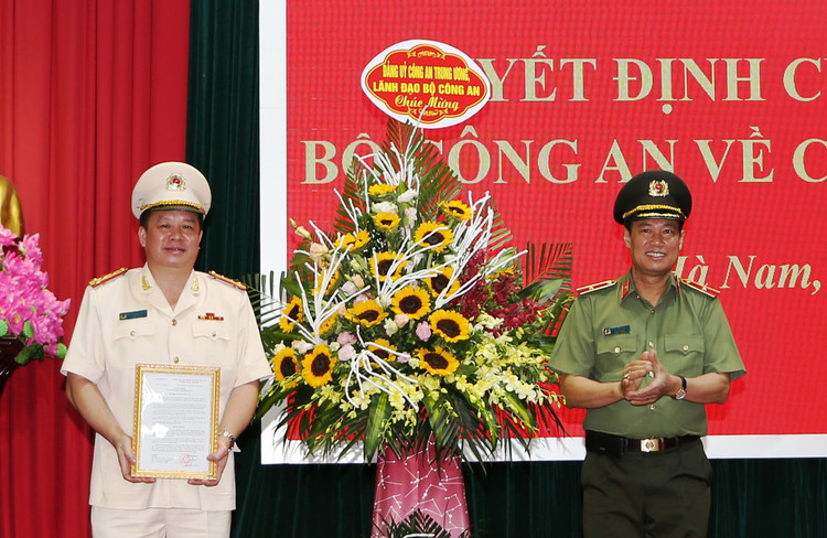 Thứ trưởng Lê Tấn Tới trao quyết định và chúc mừng Đại tá Nguyễn Quốc Hùng.