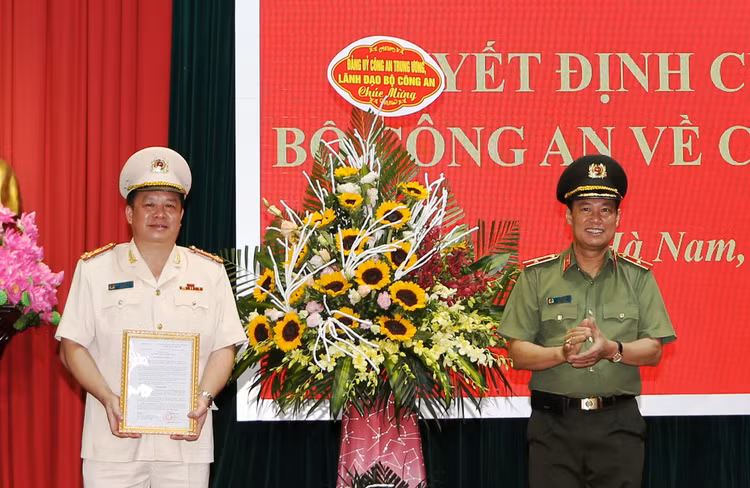 Thứ trưởng Lê Tấn Tới trao quyết định và chúc mừng Đại tá Nguyễn Quốc Hùng.