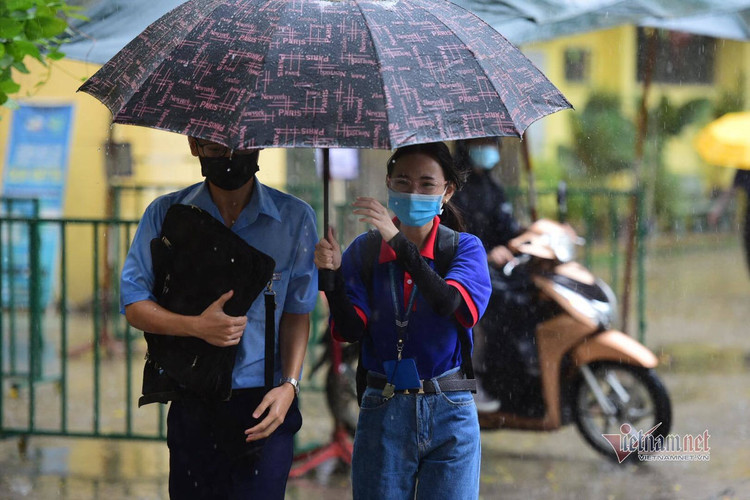 Thí sinh đến trường thi môn Toán trong cơn mưa