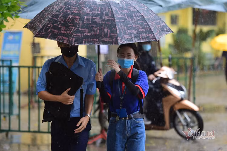 Thí sinh đến trường thi môn Toán trong cơn mưa