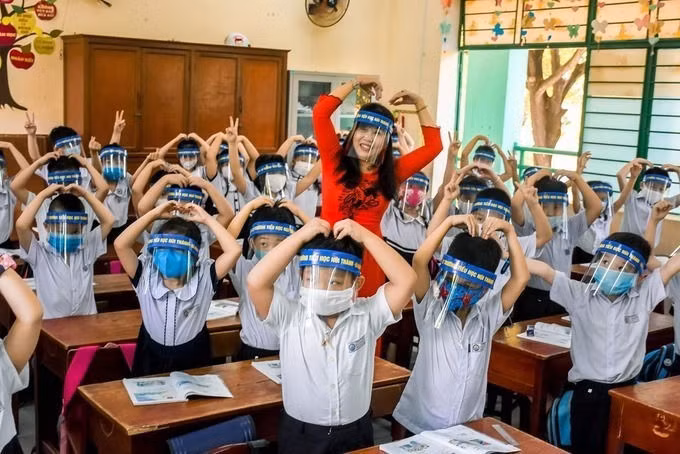 Học sinh và giáo viên trường Tiểu học Núi Thành, Đà Nẵng dùng kính chắn giọt bắn trong buổi học ngày 4/5. Ảnh:Nguyễn Đông.